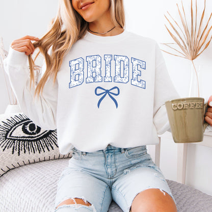 Chinoiserie Bride Sweatshirt . White sweatshirt with blue floral BRIDE lettering and bow held by woman with coffee